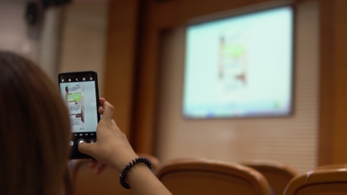 人拿着手机对着镜子自拍  描述已自动生成